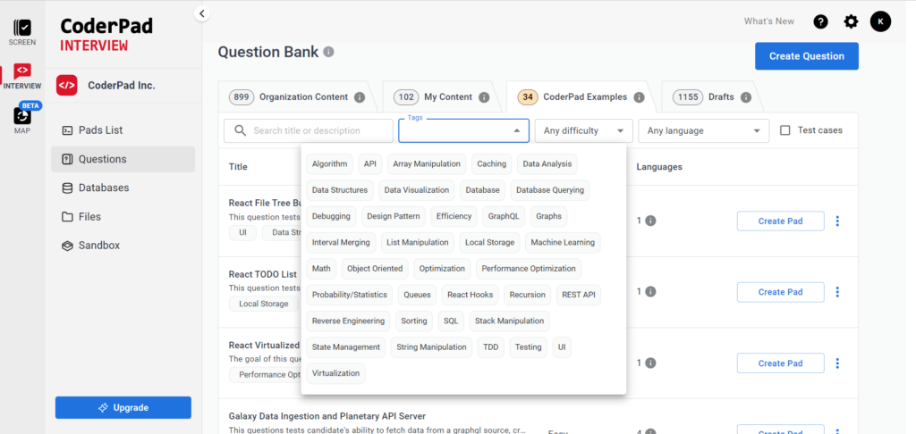 Screenshot of the CoderPad Interview platform showing the 'Question Bank' section. The interface includes a sidebar with navigation options such as 'Pads List,' 'Questions,' 'Databases,' 'Files,' and 'Sandbox.' The main section displays a search bar with filter options, including 'Tags,' 'Any difficulty,' and 'Any language.' A tag cloud with various technical topics like Algorithm, API, Array Manipulation, Data Structures, and Machine Learning is visible. Below the filters, a list of questions is shown, including titles like 'React File Tree Builder' and 'Galaxy Data Ingestion and Planetary API Server.' Each question displays associated tags and a 'Create Pad' button for further actions.